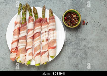 Asperges vertes en lamelles de bacon avec poivre coloré Banque D'Images