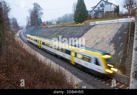 Riedlingen, Allemagne. 14 décembre 2025. Le train régional RE55 passe sur les lieux de l'accident entre les districts de Zwiefaltendorf et Zell. Plus de quatre mois après le grave accident de train qui a fait trois morts et des dizaines de blessés, les trains circulent à nouveau sur la ligne de chemin de fer touchée. Crédit : Thomas Warnack/dpa/Alamy Live News Banque D'Images