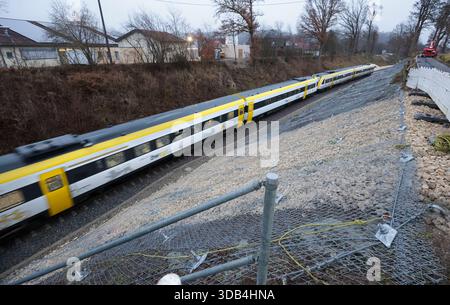 Riedlingen, Allemagne. 14 décembre 2025. Le train régional RE55 passe sur les lieux de l'accident entre les districts de Zwiefaltendorf et Zell. Plus de quatre mois après le grave accident de train qui a fait trois morts et des dizaines de blessés, les trains circulent à nouveau sur la ligne de chemin de fer touchée. Crédit : Thomas Warnack/dpa/Alamy Live News Banque D'Images