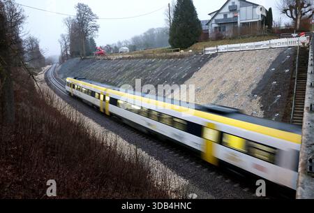 Riedlingen, Allemagne. 14 décembre 2025. Le train régional RE55 passe sur les lieux de l'accident entre les districts de Zwiefaltendorf et Zell. Plus de quatre mois après le grave accident de train qui a fait trois morts et des dizaines de blessés, les trains circulent à nouveau sur la ligne de chemin de fer touchée. Crédit : Thomas Warnack/dpa/Alamy Live News Banque D'Images