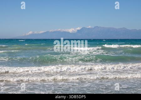 Mer Ionienne avec des vagues spectaculaires pendant une journée d'été tardive. Montagnes albanaises en arrière-plan. Ciel bleu avec des nuages blancs. Nord de l'île Corfou ( Banque D'Images