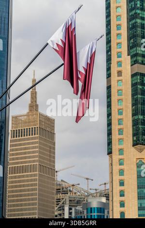 Drapeaux nationaux du Qatar contre les gratte-ciel modernes. Banque D'Images