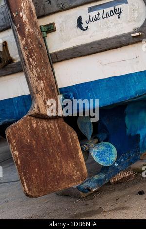 Weathered Blue peint bateau de pêche Stern avec barre en bois et hélice, nommé Just Lucky. Dorset, Angleterre Banque D'Images