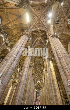 Un superbe intérieur gothique de cathédrale avec d'imposantes colonnes de pierre, des voûtes complexes et des vitraux colorés. L'architecture dramatique transmet Banque D'Images