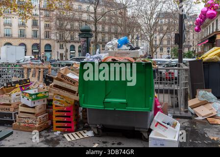 Caisses vides et conteneurs débordants laissés derrière eux après le marché de la place de la Madeleine dans le 8ème arrondissement de Paris Banque D'Images