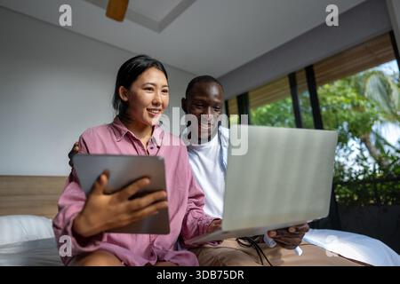 Un couple heureux et multinational qui sont des nomades numériques et travaillent dans un pays différent chaque mois Banque D'Images
