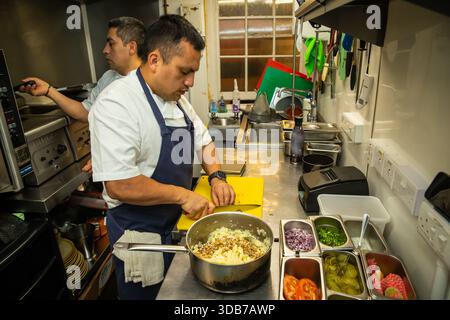 Cuisiniers préparant des aliments dans une cuisine de restaurant Banque D'Images