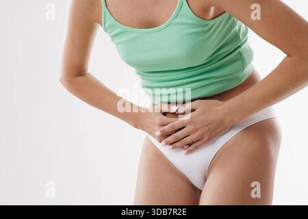 Femme souffrant de douleurs abdominales, crampes menstruelles, maux d'estomac, gêne PMS, problèmes de digestion, ou ballonnement, maintien de l'estomac dans la douleur. Banque D'Images