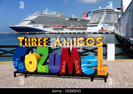 Panneau coloré « trois Amigos Cozumel » sur le front de mer avec des navires de croisière amarrés en arrière-plan au port de Cozumel, au Mexique. Banque D'Images