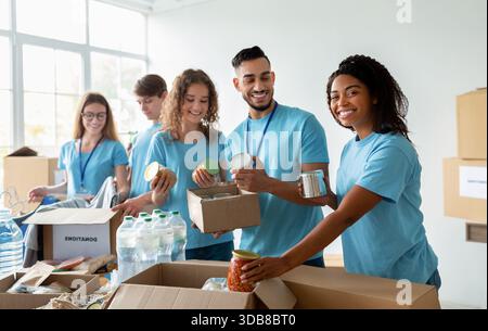 Des bénévoles travaillent ensemble pour trier les dons alimentaires pour le soutien des organismes de bienfaisance communautaires Banque D'Images