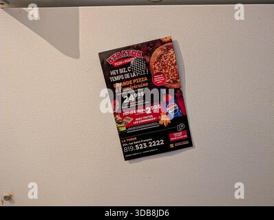 Canada, Québec, 29 novembre 2025 : publicité sur la pizza sur la porte du réfrigérateur avec promotion de pizza et de boissons américaines Banque D'Images