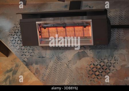 L'appareil de chauffage monté sur un mur produit une lumière chaude à l'intérieur Banque D'Images