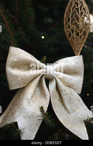 noeud or étincelant orné de motifs d'étoiles sur un arbre de noël avec ornement doré délicat dans une atmosphère de vacances festive soulignant l'élégance et Banque D'Images