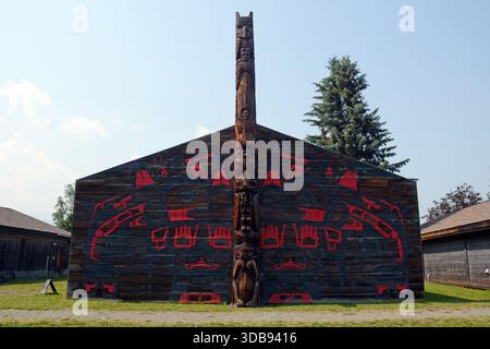 Totem et maison en bois décorée au village historique de Ksan, un site de la première nation Gitxsan à Hazelton, en Colombie-Britannique, au Canada. Banque D'Images