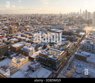 Vue aérienne d'un paysage urbain enneigé avec des bâtiments ensoleillés contrastant avec le froid, Brooklyn, New York, États-Unis. Banque D'Images