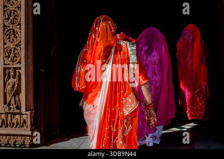 Femmes indiennes dans des voiles traditionnels colorés entrant dans une porte de temple. Banque D'Images