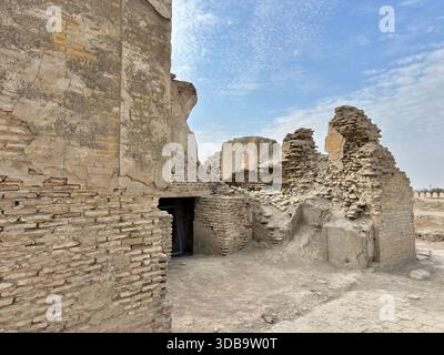Ruines antiques d'un haut mur de briques de boue avec des arches en ruines et des gravats en ruines. Banque D'Images