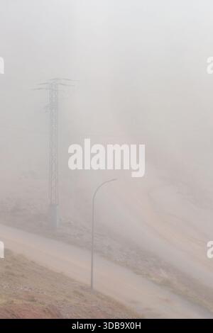 Pylône et lampadaire sur une route poussiéreuse Banque D'Images