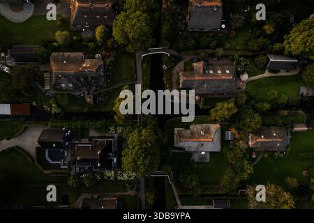 Vue aérienne des toits de chaume rencontre des canaux sereins tandis que les ponts arquent sur les voies navigables tranquilles dans le village pittoresque de Giethoorn, Overijssel, pays-Bas Banque D'Images