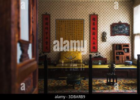 Vue sur une chambre richement décorée avec trône doré, calligraphie chinoise traditionnelle et riches textures créant une scène d'opulen historique Banque D'Images