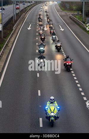 Epping, Essex, Royaume-Uni. 15 décembre 2025. PC Mathew Parker, officier motocycliste de l’unité de police de Chigwell Roads, est décédé mercredi 19 novembre sur l’A12 alors qu’il répondait à une urgence. Son cortège funéraire s'est arrêté à l'unité de circulation Chigwell de la police de l'Essex pour être rejoint par une grande escorte de policiers et d'autres services d'urgence ainsi que des clubs de motos. PC Parker était un passionné de moto et un membre du club. Le cortège se dirige vers le nord sur la M11 en direction du crématorium près de Harlow Banque D'Images
