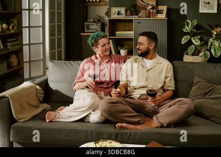 Jeune femme et jeune homme du moyen-Orient se relaxant ensemble sur canapé Banque D'Images