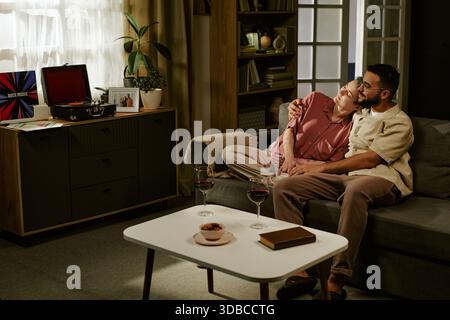 Jeune femme et jeune homme se relaxant ensemble sur Sofa at Home Banque D'Images
