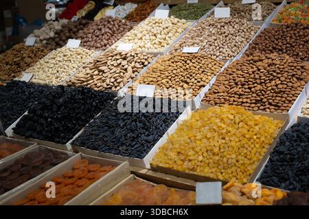Exposition de marché de fruits secs et fruits secs assortis dans des plateaux : amandes, pistaches, noix de cajou, noisettes, noix, raisins secs dorés et noirs, abricots secs Banque D'Images