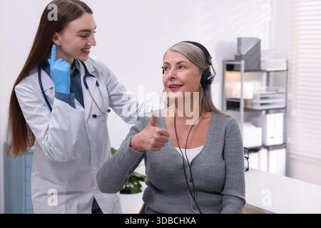 Patient porteur d'écouteurs audiométriques soumis à un test auditif en clinique Banque D'Images