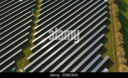 Photographie aérienne par drone d'une grande ferme solaire à Cressing, Essex, Royaume-Uni par une journée ensoleillée, montrant des panneaux photovoltaïques et la production d'énergie renouvelable. Banque D'Images
