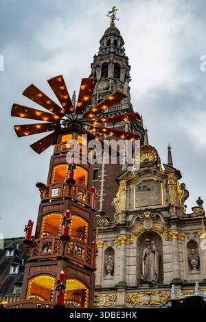 Louvain, Belgique - 14 décembre 2025 : pyramide de Noël en bois vendant des crêpes et des churros au marché d'hiver, situé en face de la KU Louvain University Lib Banque D'Images