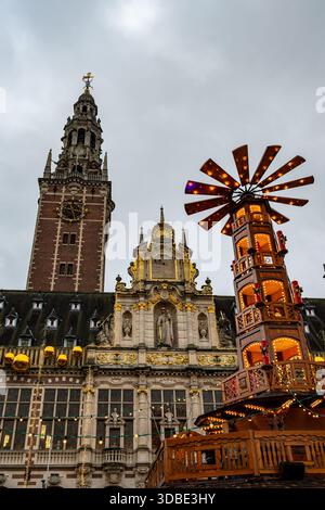 Louvain, Belgique - 14 décembre 2025 : pyramide de Noël en bois vendant des crêpes et des churros au marché d'hiver, situé en face de la KU Louvain University Lib Banque D'Images
