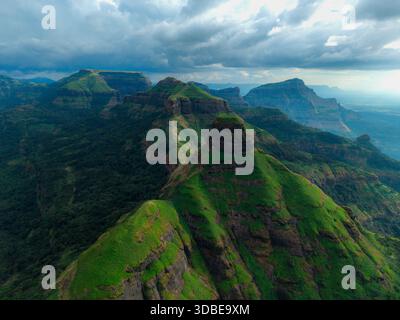 Vue aérienne des montagnes verdoyantes avec un paysage de nuages dramatique projetant des ombres à travers le paysage, Nashik, Maharashtra, Inde. Banque D'Images