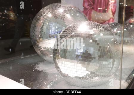 Dublin, Irlande - 12 décembre 2025 - Silver disco globes dans une vitrine à Dublin pendant la construction jusqu'à Noël dans la ville de Dublin Banque D'Images