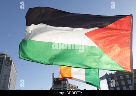Dublin, Irlande - 12 décembre 2025 - Un drapeau palestinien vu flotter à côté d'un drapeau tricolore irlandais à une stalle sur le pont O'Connell à Dublin représentant des scènes de rue dans la capitale irlandaise Banque D'Images