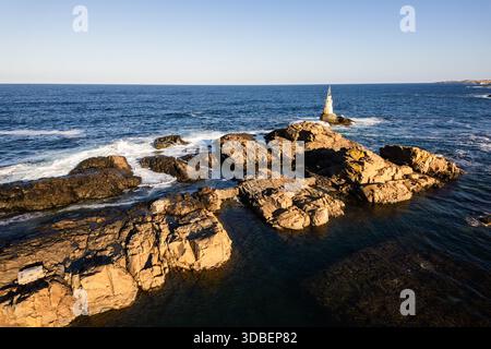 Vue aérienne du phare d'Ahtopol sentinelle debout sur un éperon rocheux au milieu de l'étreinte Azur de la mer, Ahtopol, Ahtopol, Bulgarie. Banque D'Images