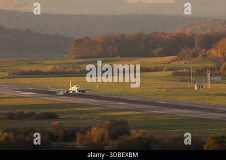 Avion de passagers atterrissant sur la piste de l'aéroport de Zurich pendant l'heure dorée. Banque D'Images