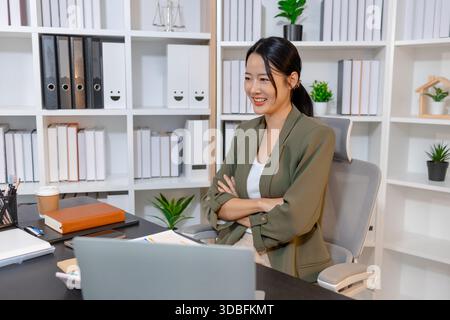 Femme d'affaires professionnelle examinant les rapports financiers et prenant des notes dans son espace de travail, axée sur la planification, la prise de décision et l'analyse de données à s. Banque D'Images