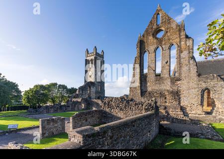 Ruines historiques de l'abbaye avec de hautes tours, des fenêtres cintrées et des murs de pierre sous un ciel bleu clair. Banque D'Images