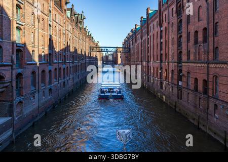 Bateau touristique dans le célèbre quartier des entrepôts Speicherstadt à Hambourg, Allemagne Banque D'Images