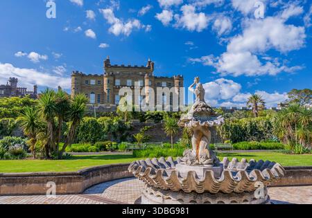 Une vue panoramique sur le château de Culzean avec une fontaine décorative dans un jardin luxuriant et ensoleillé. Banque D'Images