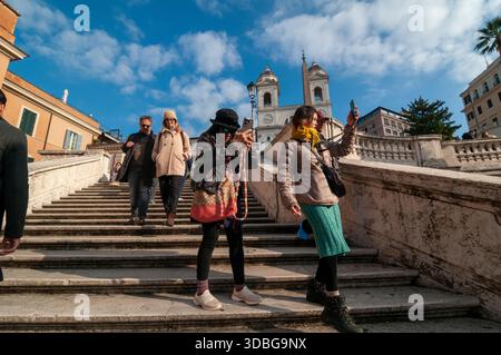 Les touristes japonais descendent les marches espagnoles tout en prenant des photos sur smartphone. Rome Banque D'Images