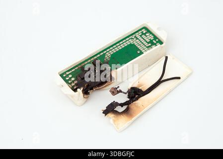 Circuit d'alimentation électronique brûlé et fondu après court-circuit électrique isolé sur blanc Banque D'Images