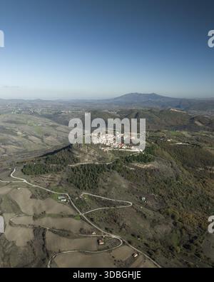 Vue aérienne d'un village perché se prélasser sous un ciel clair, mettant en valeur le charme rustique des anciens bâtiments en pierre et des routes sinueuses, Cairano, Irpinia Banque D'Images