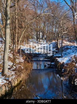 Wolf Creek est un ruisseau qui coule dans les Hackensack Meadowlands dans le comté de Bergen, New Jersey, États-Unis. Photographié ici avec de la neige et des reflets. Banque D'Images