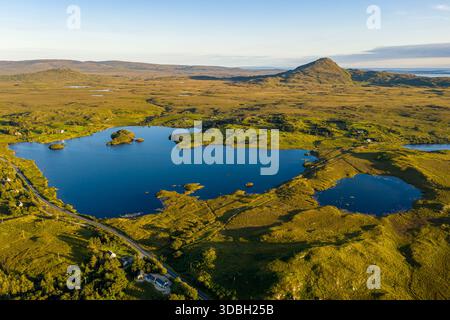 La vue plongeante capture un vaste paysage rural avec des lacs bleus interconnectés, des champs verts et des collines lointaines, galway, Irlande Banque D'Images