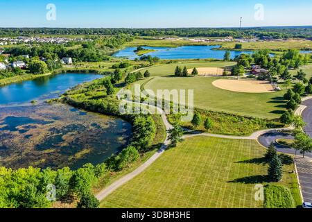 Vue aérienne du parc Algonquin Lakes dans l'Illinois Algonquin, avec terrains de baseball, espaces verts, sentiers pédestres et vues panoramiques sur le lac. Banque D'Images