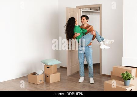 Happy couple célèbre son déménagement dans sa première maison avec joie et rire Banque D'Images