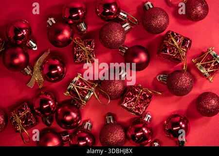 Concept de décorations de Noël. Vue de dessus vue de dessus gros plan photo de boules brillantes rouges magnifiquement décorées isolées sur fond rouge Banque D'Images