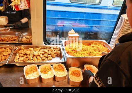 Non exclusif : un volontaire du Food train, qui fournit des repas chauds aux personnes laissées sans électricité et sans chauffage en raison d'une attaque russe, prépare des déjeuners s. Banque D'Images